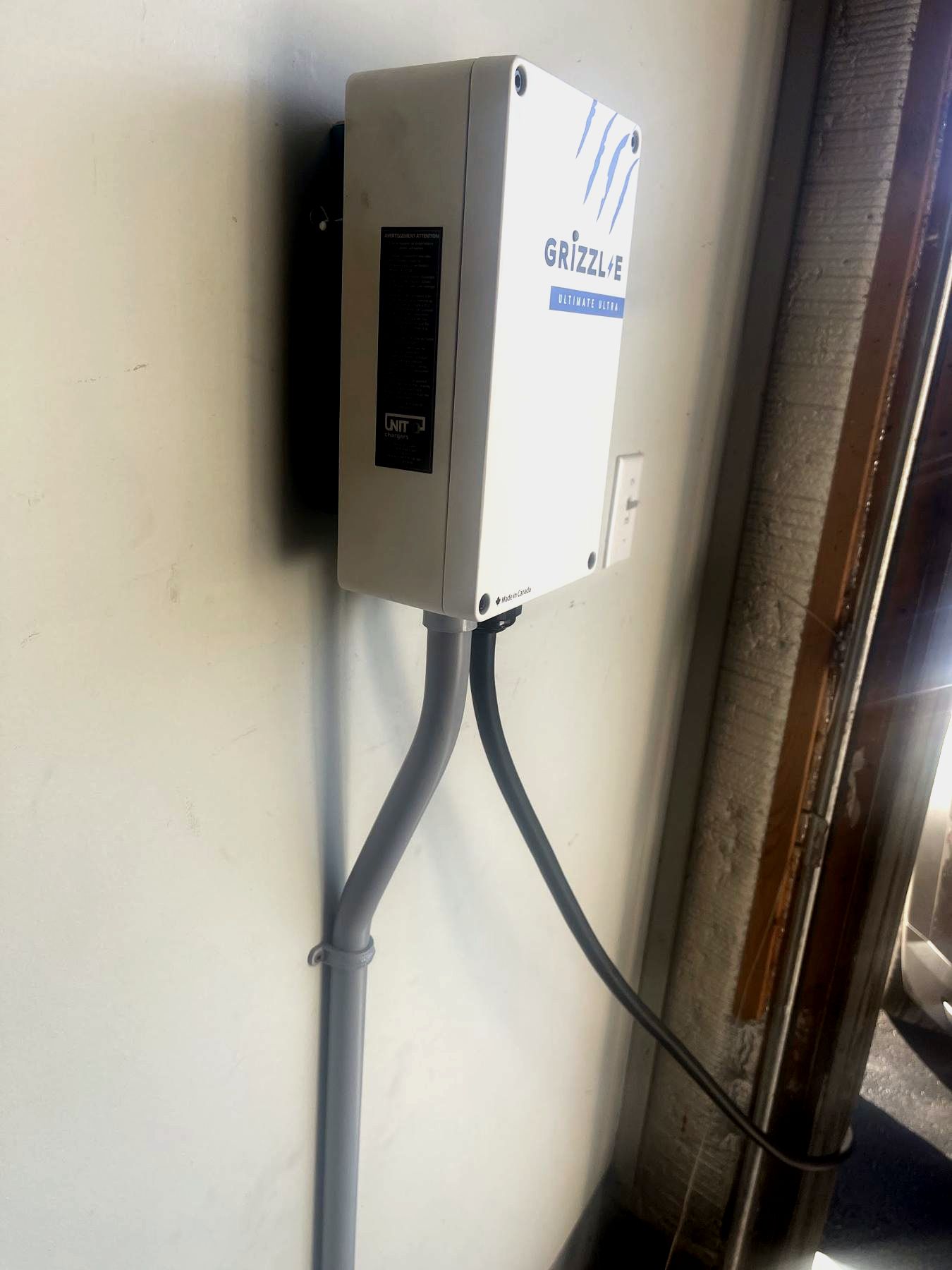A wall-mounted EV charger with its supply run in conduit