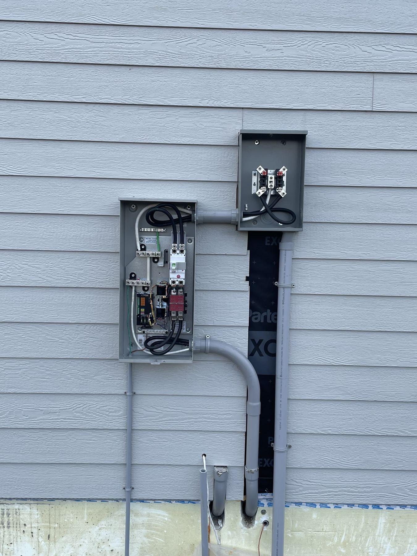 An exterior disconnect and meter on the side of a house