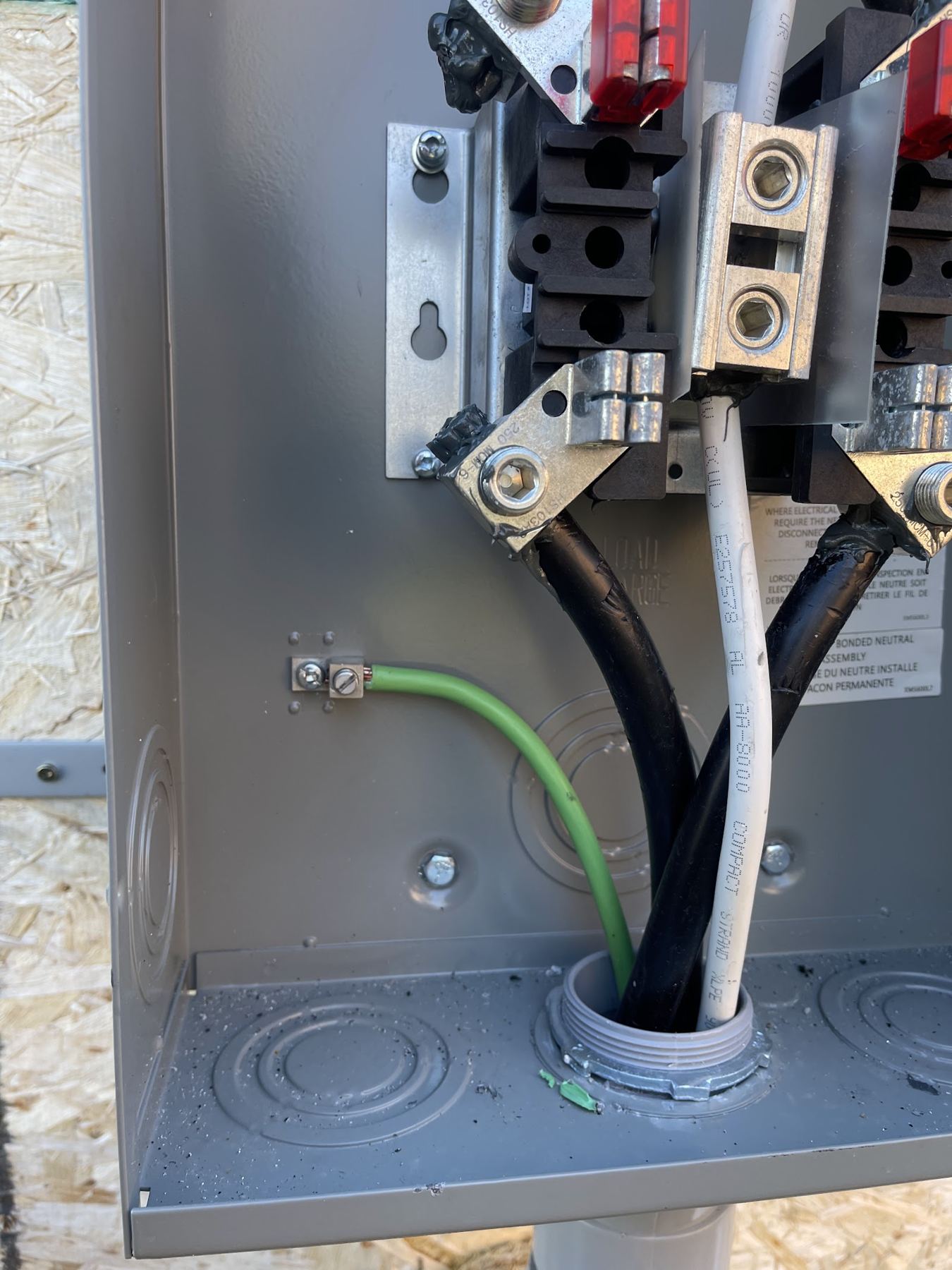 The inside of a meter base with the service conductors landed
